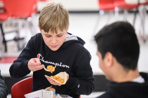 Fegley Middle School sixth grader Ayden Edwards loads up a taco with arroz con pollo, made with principal Ann Marie Caballero's family recipe, during a special lunch on Wednesday, Jan. 29, 2025. (Kyle Telechan/for the Post-Tribune)