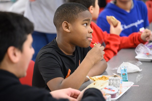 Fegley Middle School sixth grader Cyrion McKenzie takes a bite of arroz con pollo, made with principal Ann Marie Caballero's family recipe, during a special lunch on Wednesday, Jan. 29, 2025. (Kyle Telechan/for the Post-Tribune)