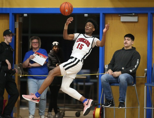 21st Century forward Lemetrius Williams (15) attempts to keep a ball in-bounds during the fourth quarter of the Class 2A North Judson Regional championship game at North Judson-San Pierre High School in North Judson, Ind. on Saturday, March 9, 2023. (Trent Sprague/for The Post-Tribune)