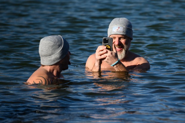 Miller resident Eric Tonk, on right, takes video of friend and fellow Miller Beach Swim Club member Michael Matrejek during the Burns Harbor Park Department's Polar Plunge event at Lakeland Park on Saturday, Jan. 4, 2025. (Kyle Telechan/for the Post-Tribune)