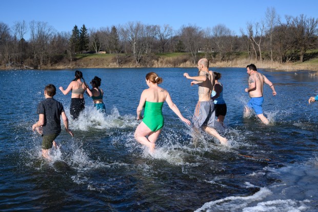 Polar plungers wade into the lake at Burns Harbor's Lakeland Park during an event to raise funds for the Burns Harbor Park Department on Saturday, Jan. 4, 2025. (Kyle Telechan/for the Post-Tribune)