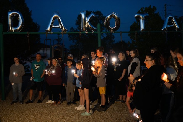 Visitors use candles and their phones to illuminate the area around them during a candlelight vigil for Dakota Levi Stevens, 10, in Valparaiso on Tuesday, May 7, 2024. (Kyle Telechan/for the Post-Tribune)