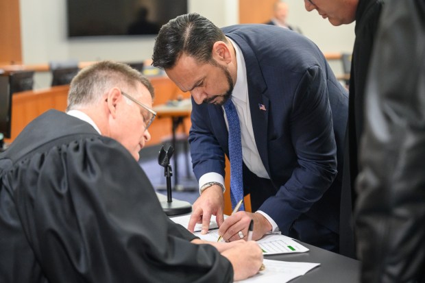 Incoming Porter County District 1 commissioner Ed Morales signs documents after being sworn in during a ceremony in Valparaiso on Wednesday, Jan. 1, 2025. (Kyle Telechan/for the Post-Tribune)