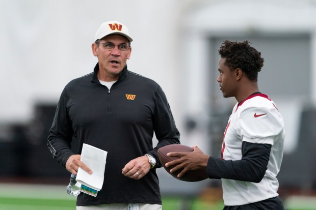 Washington Commanders coach Ron Rivera, left, talks with wide receiver Jahan Dotson during rookie minicamp at the team's training facility, May 6, 2022 in Ashburn, Va.