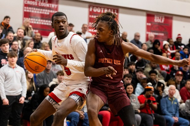 Marist's Stephen Brown (5) tries to get to the lane as Brother Rice's K J Morris (1) guards him during a nonconference game in Chicago on Tuesday, Jan. 21, 2025. (Vincent D. Johnson / for the Daily Southtown)