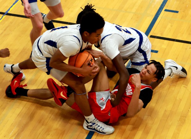 Sandburg's Malachi Perkins, left, and Homewood-Flossmoor's Brent Taylor, right, battle on the ground for the ball during the basketball game in Orland Park on Friday, Jan. 24, 2025. (James C. Svehla / for the Daily Southtown)