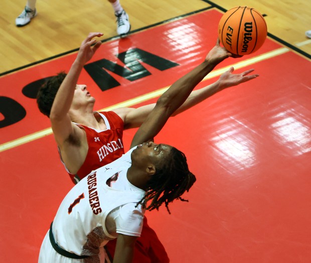 Brother Rice's KJ Morris, front, and Hinsdale Central's Michael Howell reach for a rebound during the Hinsdale Central Holiday Classic championship game in Hinsdale on Monday, Dec. 30, 2024. (James C. Svehla / for the Daily Southtown)