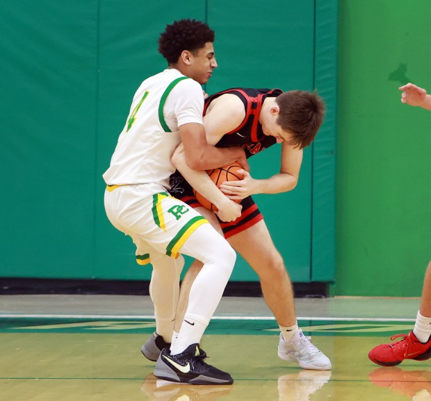 Lincoln-Way Central's Logan Baechtold, right and Providence's Kelechi Eniya, left, battles for the ball during the basketball game in New Lenox on Saturday, Jan. 4, 2025. (James C. Svehla / for the Daily Southtown)