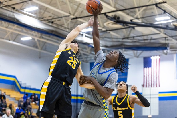 St. Laurence's Jacob Rice (25) and De La Salle's Jordan Shaw (32) battle for a rebound during a Catholic League crossover game in Chicago on Tuesday, Jan. 4, 2025. (Vincent D. Johnson / for the Daily Southtown)