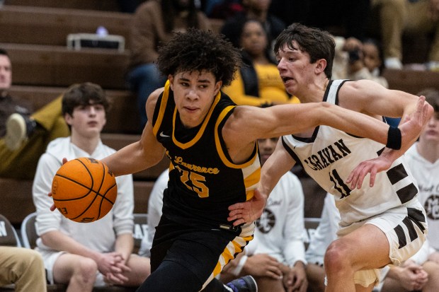 St. Laurence's Jacob Rice (25) drives past Mount Carmel's Kyle Chevalier (11) during a Catholic League crossover game in Chicago on Tuesday, Jan. 28, 2025. (Vincent D. Johnson / for the Daily Southtown)