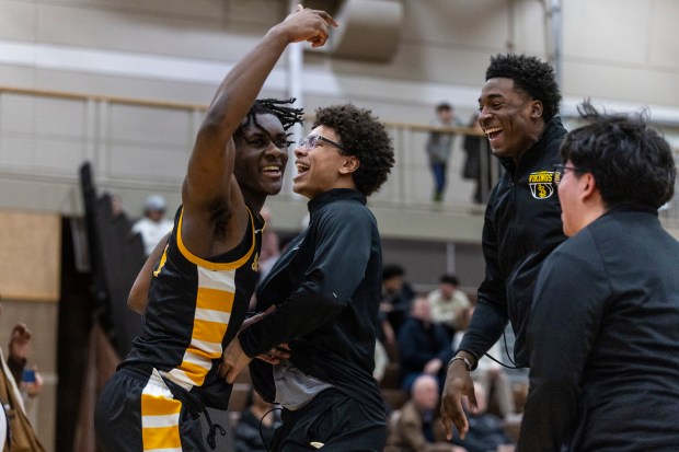 St. Laurence's Zerrick Johnson, left, is mobbed by his teammates after finishing their game against Mount Carmel with a dunk as times expired in a Catholic League crossover match in Chicago on Tuesday, Jan. 28, 2025. (Vincent D. Johnson / for the Daily Southtown)