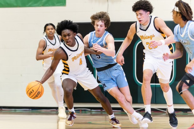 St. Laurence's Zerrick Johnson (4) steals the ball from Downers Grove South's Wyatt Wawro (5) during the Jack Tosh Holiday Classic third-place game in Elmhurst on Tuesday, Dec. 31, 2024. (Troy Stolt / for the Daily Southtown)