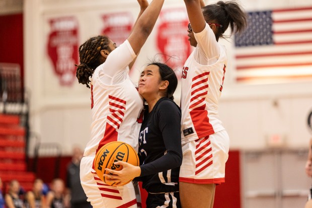 Lincoln-Way East's Mia Limpin tries to get a shot off between Homewood-Flossmoor's Ashlynn Magee, left, and Aunyai Deere during a Southwest Suburban Conference game in Flossmoor on Thursday, Jan. 9, 2025. (Vincent D. Johnson / for the Daily Southtown)