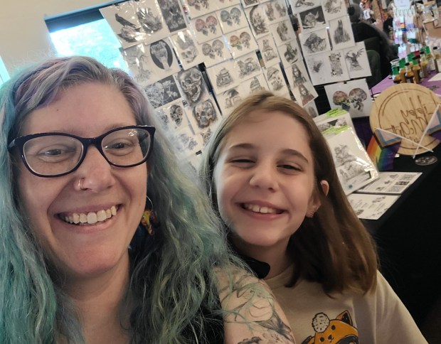 Libby McArthur's daughter Evey helps her mother during a show. "I sell my work at artists' markets in the area and show it in some of the local libraries, but it's cool when people see my art for the first time," Libby McArthur said. "I get asked a lot if I'm a tattoo artist." (Libby McArthur)