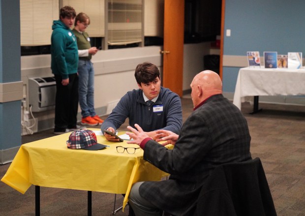 Palos Leo Club treasurer Ethan Halikias discusses smartphone apps with a resident during a recent tutoring session the club hosted to give older adults insights into electronic devices. A nursing home has expressed interest in having members tutor its residents as well. (Lions International)