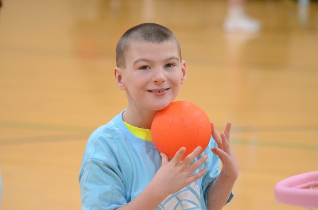 Rhett Coglianese smiles before dunking a toy basketball into the hoop at the Super Celtics camp Jan. 2, 2025. (Jeff Vorva/for the Daily Southtown)