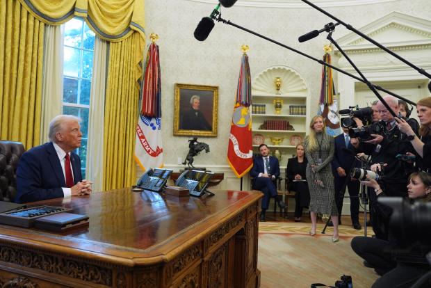 President Donald Trump talks with reporters as he signs executive orders in the Oval Office at the White House, Thursday, Jan. 30, 2025, in Washington. (AP Photo/Evan Vucci)