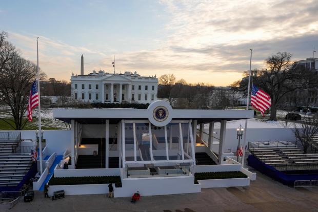 Workers continue with the finishing touches on the presidential reviewing stand on Pennsylvania outside the White House Thursday, Jan. 16, 2025, in Washington, ahead of President-elect Donald Trump's inauguration. (Jon Elswick via AP)