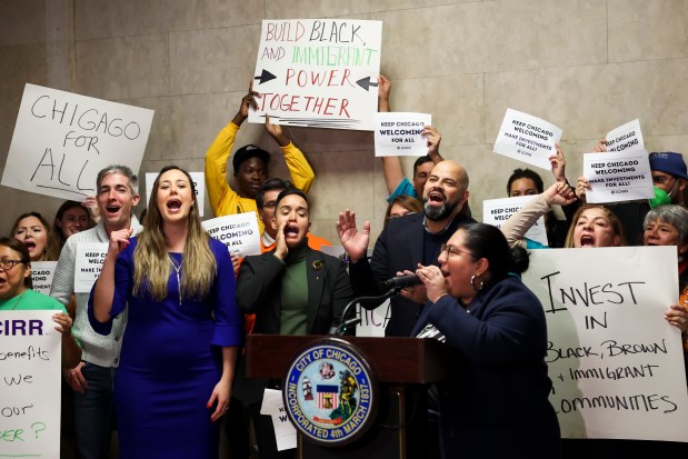 Cinthya Rodriguez, with Mijente, leads aldermen and immigrant community leaders in a chant to celebrate after advocates of Chicago's sanctuary city status blocked the item that would have put Chicago's status on the March ballot, after a special City Council meeting on Dec. 14, 2023. (Eileen T. Meslar/Chicago Tribune)