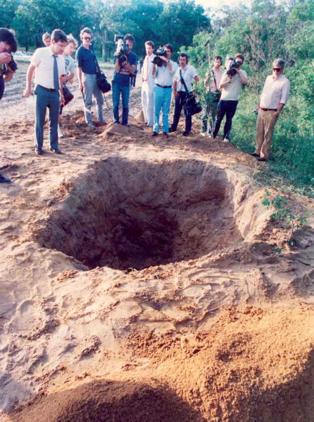 Members of the news media gather at a hole in the ground in an Indiana cornfield after the Spilotro brothers' bodies were found there in June 1986. (Phil Greer/Chicago Tribune) 