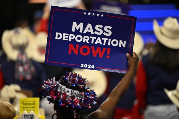 An attendee holds up a sign reading "mass deportations now!" during the third day of the 2024 Republican National Convention at the Fiserv Forum in Milwaukee, Wisconsin, on July 17, 2024. (Patrick T. FallonGetty-AFP)