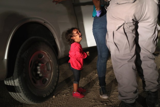 A two-year-old Honduran asylum seeker cries as her mother is searched and detained near the U.S.-Mexico border on June 12, 2018, in McAllen, Texas. The asylum seekers had rafted across the Rio Grande from Mexico and were detained by U.S. Border Patrol agents before being sent to a processing center for possible separation. (John Moore/Getty)