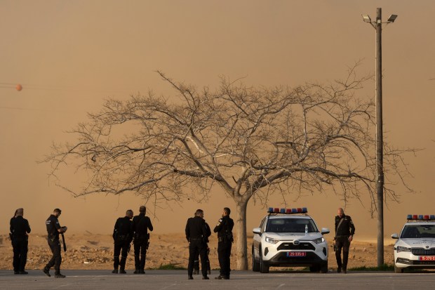 ,Israeli police stand near a dust cloud kicked up by a departing helicopter after the first phase of a ceasefire agreement began between Israel and Hamas on Jan. 19, 2025 near the Gaza border near Re'im, Southern Israel. (Amir Levy/Getty)