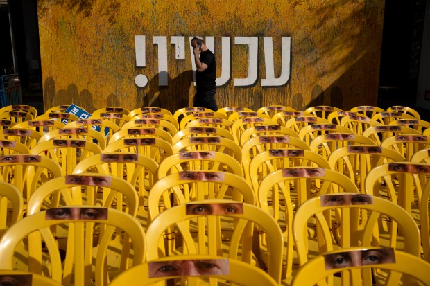 A display of yellow chairs representing hostages held in the Gaza Strip, and a banner reading "now!" in Hebrew, are seen in Tel Aviv, Israel, on the first day of a ceasefire between Israel and Hamas, as three hostages are set to be released from captivity on Jan. 19, 2025. (Maya Alleruzzo/AP)