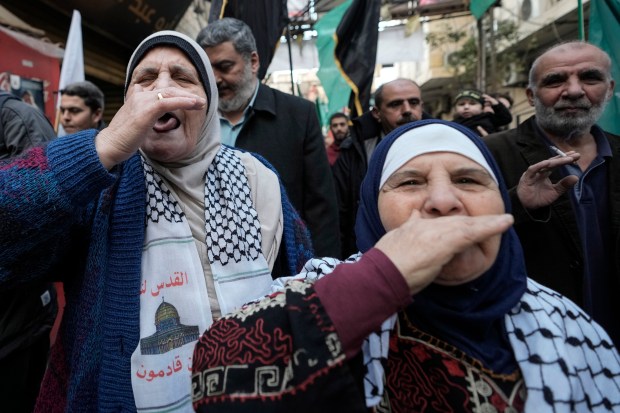 Palestinians let out a "zaghrouta" or joyous yell to celebrate a ceasefire agreement between Hamas and Israel at the Burj al-Barajneh Palestinian refugee camp, south of Beirut, Lebanon on Jan. 19, 2025. (Hassan Ammar/AP)