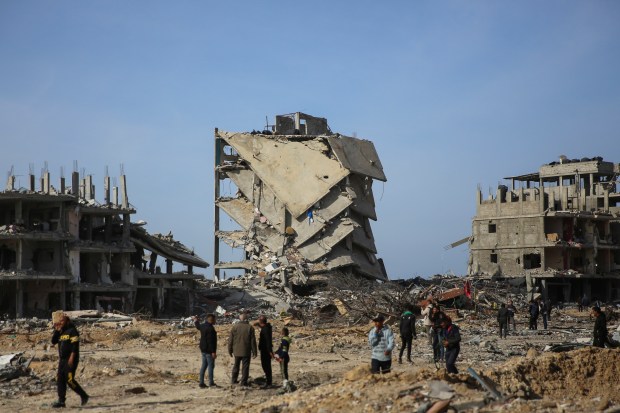 Palestinians inspect the destruction caused by the Israeli air and ground offensive on Jan. 19, 2025, in Rafah, as a ceasefire deal between Israel and Hamas went into effect. (Mohammad Hajjar/AP)