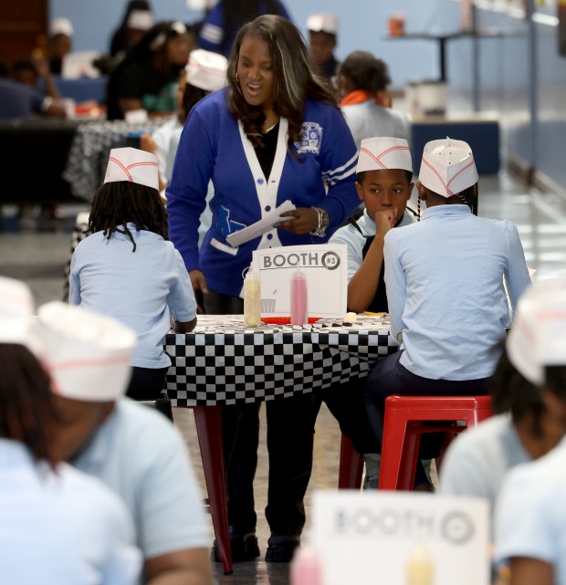 Fifth-grade teacher Tamara Leachman works with her students during a "hallway burst" as they present projects in a hallway at Avalon Park Fine & Performing Arts School, Jan. 9, 2025. (Antonio Perez/Chicago Tribune)