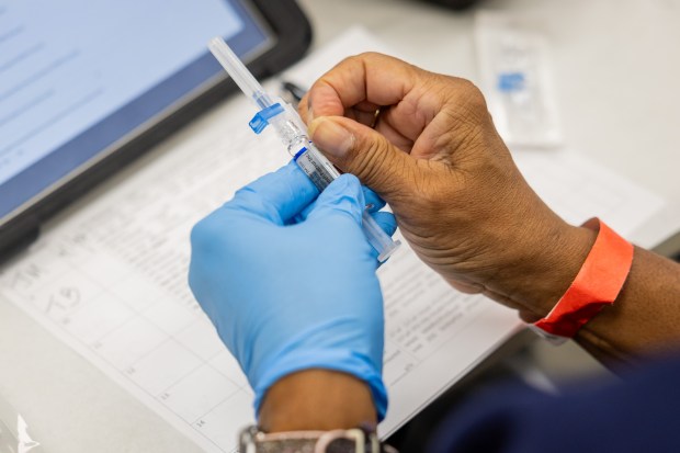 Registered nurse Donna Feaster prepares to administer a flu shot during a 9th Ward COVID-19 and flu vaccination clinic at the Pullman Community Center in Chicago on Oct. 10, 2024. (Tess Crowley/Chicago Tribune)