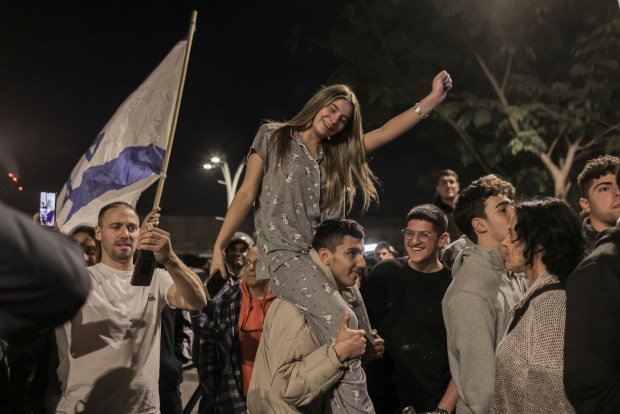 People gathering near a hospital in Ramat Gan, Israel, react after the first hostages were released at the start of the ceasefire agreement between Israel and Hamas on Jan. 19, 2025. (Avishag Shaar-Yashuv/The New York Times)