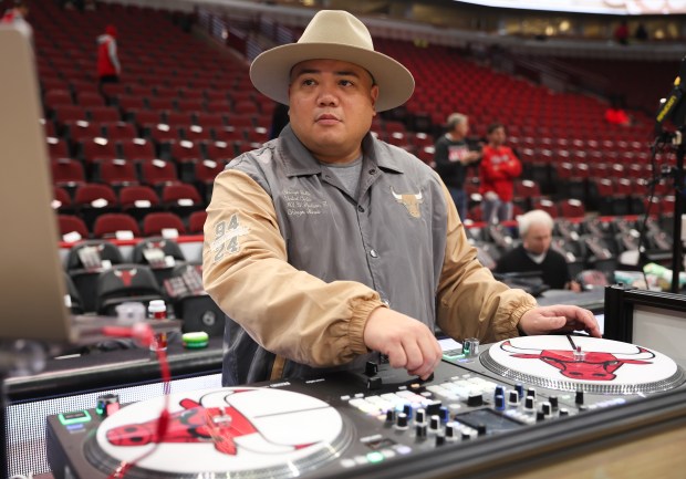 Joseph Ejercito, known professionally as DJ JayFunk, works a turntable during a rehearsal prior to a Chicago Bulls basketball game at the United Center on Dec. 28, 2024. (Talia Sprague/for the Chicago Tribune)