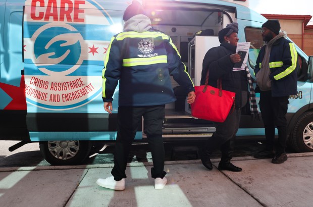 Erminia Williams, center, steps down after touring the Crisis Assistance Response and Engagement (CARE) van outside of the Roseland East 115th Street Health Hub on Jan. 8, 2025, in Chicago. The van is dispatched to mental health calls in Chicago and includes an EMT and clinician to assist with mental health issues. (Stacey Wescott/Chicago Tribune)