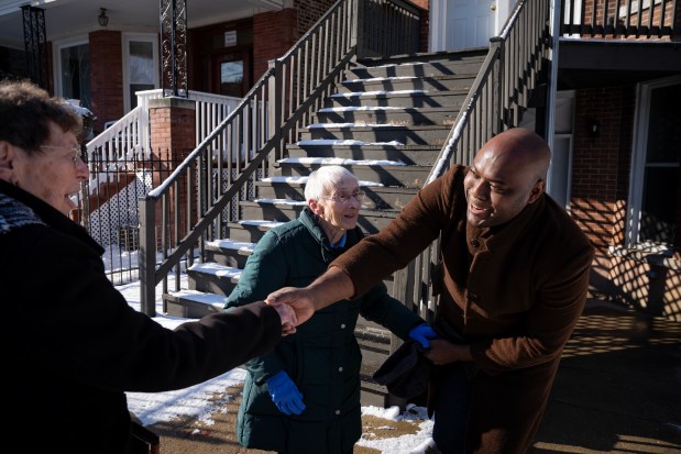 Oscar Alfonso Appleton, a migrant from Panama, greets Sisters JoAnn Persch, left, and Pat Murphy as they visited his family at their home on the Southwest Side, Jan. 11, 2025. (E. Jason Wambsgans/Chicago Tribune)