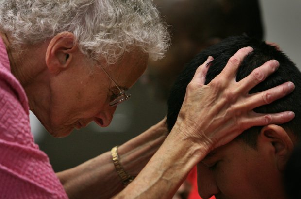 Sister Pat Murphy prays with an immigration detainee at the McHenry County Jail on July 21, 2009. (Alex Garcia/Chicago Tribune)