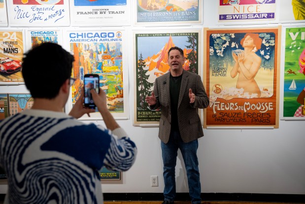 Andrew Zavelson films a TikTok video on Jan. 8, 2024, at his business, Chicago Vintage Posters, on the Lower West Side. (E. Jason Wambsgans/Chicago Tribune)