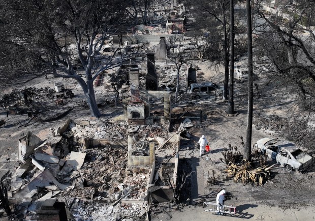 People search through the remains of their burned home on Jan 19, 2025, in Altadena, California. They said they plan to rebuild. (Mario Tama/Getty)