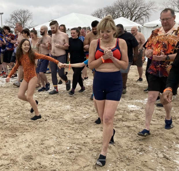 Polar Bear Plunge participants charge down the beach as they prepare to hit the water. (Steve Sadin/For the Lake County News-Sun)