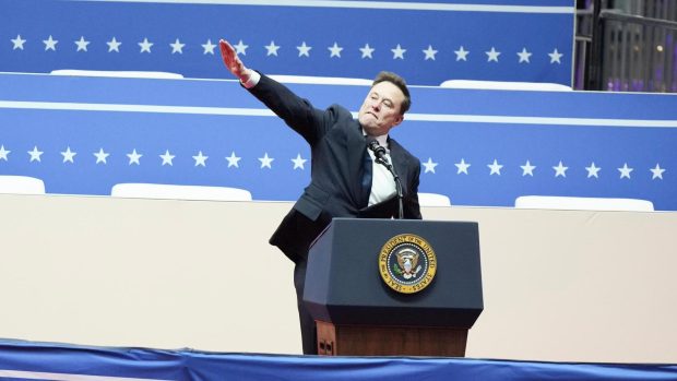 Elon Musk gestures as he speaks during the inaugural parade inside Capitol One Arena following President Donald Trump's inauguration as the 47th president in Washington, Jan. 20, 2025. Speaking at a celebratory rally in Washington, Musk twice extended his arm out with his palm facing down, drawing comparisons to the Nazi salute. (Eric Lee/The New York Times)