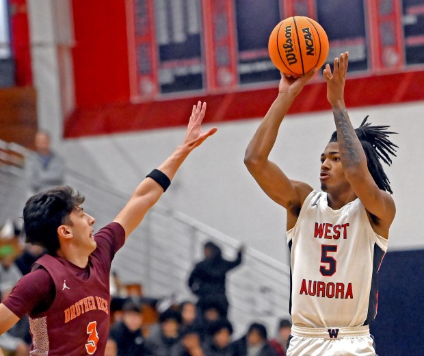 West Aurora's Terrence Smith shoots a jump shot over Brother Rice's Marcos Gonzalez. West Aurora defeated Brother Rice in a boys basketball game 56-51 Saturday, Feb. 8, 2025, in Aurora, Illinois. (Jon Langham/for the Beacon-News)