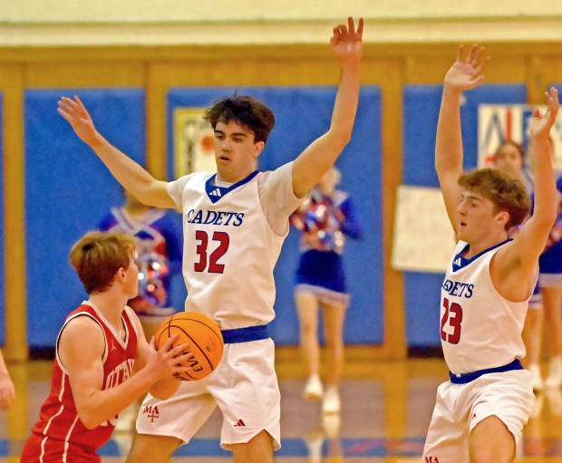 Marmion's Samuel Dalmann and Joseph Krameer defend against Ottawa's Evan Snook. Marmion defeated Ottawa in a boys basketball game 66-58 Tuesday, Feb. 18, 2025, in Aurora, Illinois. (Jon Langham/for the Beacon-News)