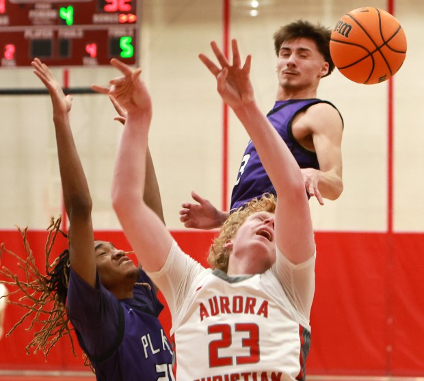 Plano's Taron Mcgowan, left, Vinny Cesario, back, and Aurora Christian's Asa Johnson, right, battle for a loose ball during the boys basketball game in Aurora on Friday, Feb. 21, 2025. (James C. Svehla / for the Beacon-News)