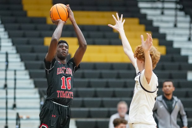 East Aurora's Marcus Wallace jr (10) shoots a three pointer against Streamwood's Adam Hovey (right), during an Upstate Eight West conference basketball game at Streamwood High School on Thursday, Feb. 13, 2025. (Sean King / for The Beacon-News)