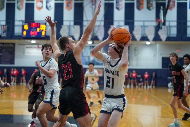 Yorkville's Taelor Clements (left), defends the paint against Oswego East's Andrew Pohlman during a Southwest Prairie Conference basketball game at Oswego East High School on Friday, Feb. 14, 2025. (Sean King / for The Beacon-News)