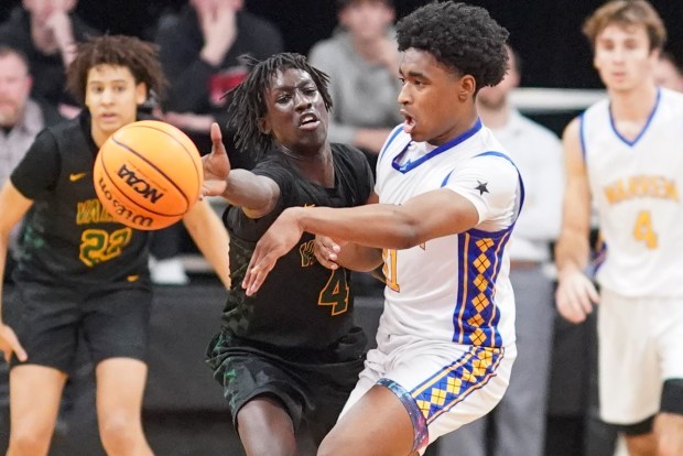 Waubonsie Valley's Moses Wilson (4) deflects a pass from Warren's Braylon Walker (11) with 7 seconds left in the 4th quarter of play during an Indian Creek Shootout basketball game at Indian Creek High School in Shabonna on Saturday, Feb. 15, 2025. (Sean King / for The Beacon-News)