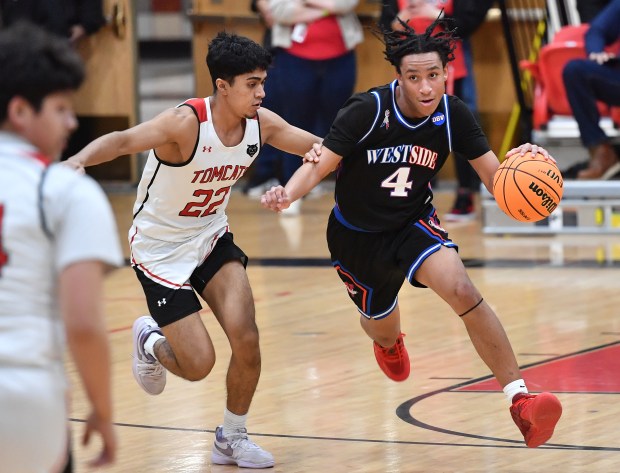 West Aurora's Antonio Higgins (4) drives as East Aurora's Joel Navarro defends during a game on Friday, Feb. 7, 2025 in Aurora...(Jon Cunningham/for The Beacon-News)