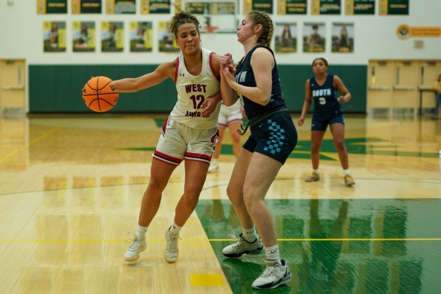 West Aurora's Brooklynn Johnson (12) posts up against Downers Grove South's Mila Kosanovic-cruise (23) during a Class 4A Waubonsie Valley Regional semifinal basketball game at Waubonsie Valley High School in Aurora on Monday, Feb. 17, 2025. (Sean King / for The Beacon-News)