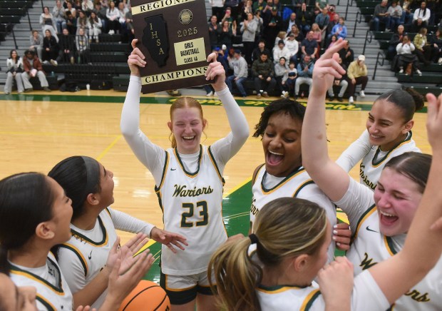 Waubonsie Valley's Lily Newton (23) holds up the championship plaque after defeating West Aurora 82-44 during the Class 4A Waubonsie Valley Regional final Thursday, Feb. 20, 2025 in Aurora, IL. (Steve Johnston/for The Beacon-News)